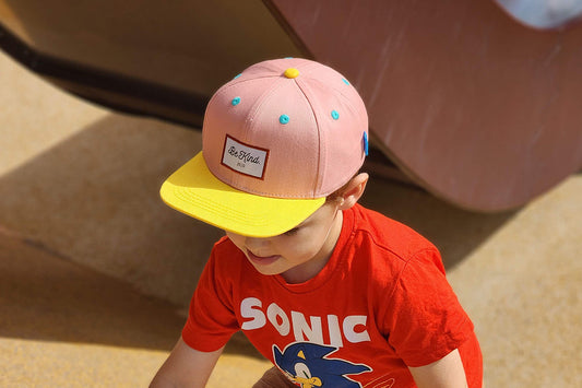 A kid in a cool cap plays in the sun.